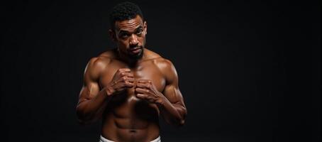 Muscular African American boxer with sweaty forehead leaning on left elbow and covering eyes with right hand photo