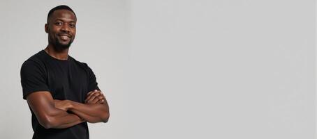 African American male model poses in a blank black tee perfect for logodesign placement on a neutral backdrop photo