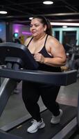 Obese woman exercising on a treadmill photo