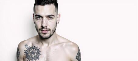 Modern man portrait featuring tattoos and piercings against a monochrome backdrop photo