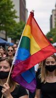 A vibrant rainbow flag with gradient colors symbolizes LGBTQ pride and unity at a diverse festive parade celebrating the LGBT communitys equality and acceptance photo