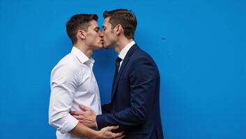 A heartfelt romantic moment between two men set against a striking blue backdrop photo