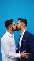 A heartfelt romantic moment between two men set against a striking blue backdrop photo
