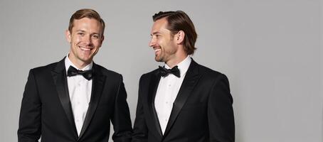 Two grooming muscular grooms one blonde the other brunette both sporting tuxedos smiles photo