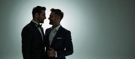 Exquisite studio portrait of gay couple using cinematic lighting against simple background photo