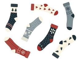 Set of cozy winter socks with playful patterns, including snowflakes, hearts, trees, and stripes. These festive socks are arranged in a fun, scattered layout, showcasing a cute and minimal flat style. vector