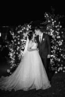 girl and guy against the background of a night wedding arch photo