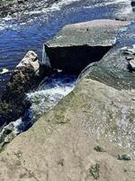 a man is standing on a rock in the water photo