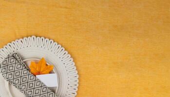 Elegant fall table setting with a single leaf and napkin, place for text photo