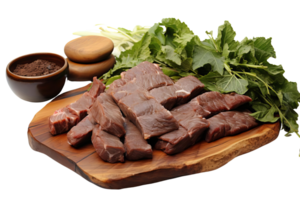 A plate of meat is on a wooden cutting board. The meat is cut into small pieces and is surrounded by green leaves png
