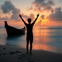 A man is standing on the beach with his arms raised photo
