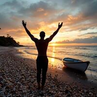 A man is standing on the beach with his arms raised photo