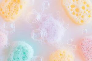 Bright sponges and sparkling soap bubbles abstract cleaning background. photo