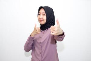 portrait of Indonesian Asian woman wearing shirt and hijab showing ok sign with one hand on eyes looking at camera through fingers. giving sign of agreement. Isolated on white Background photo
