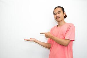 Asian, Indonesian man standing wearing pink shirt pointing right, left, up, down and presenting using hand gestures. Isolated on white background photo