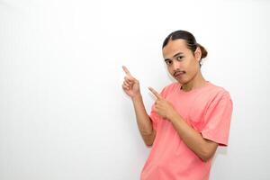 Asian, Indonesian man standing wearing pink shirt pointing right, left, up, down and presenting using hand gestures. Isolated on white background photo