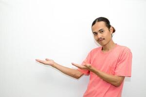Asian, Indonesian man standing wearing pink shirt pointing right, left, up, down and presenting using hand gestures. Isolated on white background photo