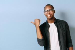 portrait of a young black man pointing his finger. Smiling African American pointing to the side of him. photo