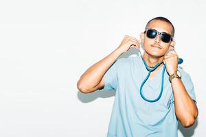 man dressed as doctor with summer sunglasses, smiling and cheerful. summer concept. photo