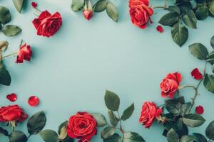 There are red roses along with green leaves set against a blue background photo