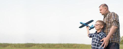 Banner father and son in a field with an airplane. Father's day concept. photo