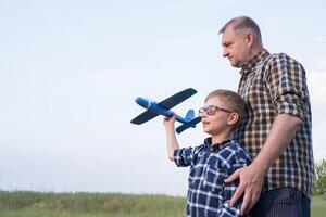 Father and son having fun in the field playing with an airplane photo