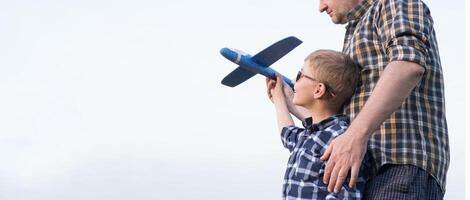 Father and son having fun in the field playing with an airplane photo