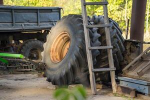 Detail of two tractor tires and a wooden ladder standing on a farm in Ukraine photo
