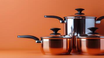 Shiny copper cookware lined up on a wooden surface in a warm toned kitchen setting photo