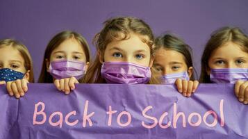 Group of children holding a back to school banner while wearing face masks in a classroom photo