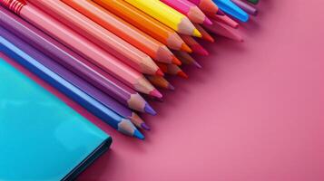 Colorful stationery collection on a vibrant pink background for creative writing and art photo