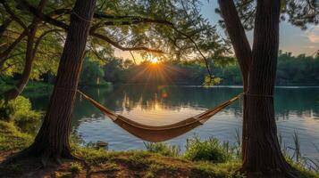 Relaxing hammock by a tranquil lake surrounded by lush trees on a sunny day photo