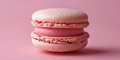 Delicate pink macaron resting on a pastel surface with scattered crumbs and decorations photo
