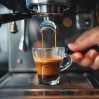 Barista preparing espresso shot with a coffee machine in a cozy cafe during the afternoon photo