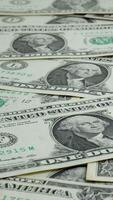 A collection of one dollar bills lies on a flat surface, displaying intricate designs and the iconic green tint of U.S. currency. The focus is on the texture and patterns of the bills. video
