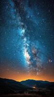 Starlit night over a calm sea reflecting the Milky Way in clear twilight skies photo