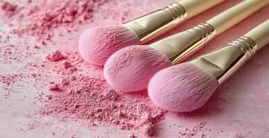 Three pink makeup brushes with soft bristles and scattered blush powder on a pink background photo