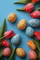 Colorful spring flowers and Easter eggs arranged beautifully on a blue background photo