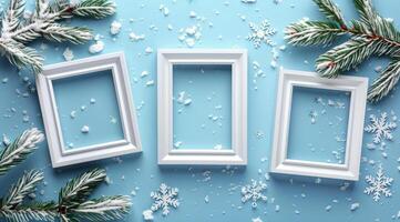 Three White Frames With Snowy Pine Branches On Blue Background photo