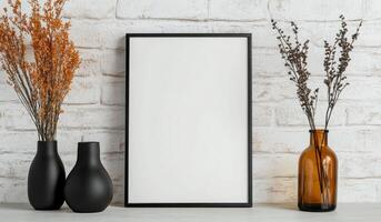 Elegant home decor display with empty frame and decorative vases on a brick wall photo