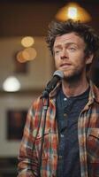 A young man performs stand up comedy at a lively bar during a bustling night in the city photo