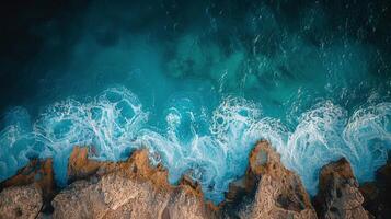 Vibrant coastal view featuring rocky shoreline and turquoise waves on a sunny day photo