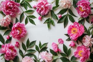 A vibrant arrangement of lush green leaves and coral peonies on a light background photo