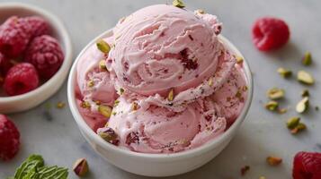 Creamy raspberry pistachio ice cream served in a white bowl with fresh berries on the side photo