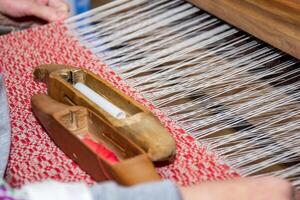 Old craft. Elements of ancient weaving loom in an interior of a wooden log hut. photo