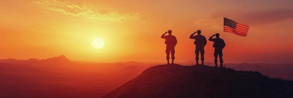 Three soldiers stand on a hillside, saluting while holding an American flag during a stunning sunset photo
