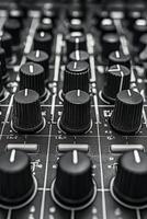 Detailed close up of a mixing console with black knobs used in music production photo