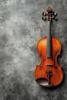 A beautifully crafted violin rests against a textured gray background with elegant detailing photo