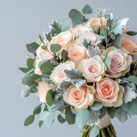 Elegant bouquet of soft pink and cream roses with eucalyptus leaves arranged for special occasions photo