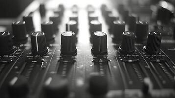 A close up view of an audio mixing console with various knobs and sliders in a studio setting photo